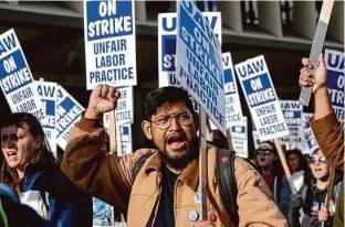  ?? Salgu Wissmath/The Chronicle ?? Graduate student researcher Tanzil Chowdhury marches with UC workers in Oakland last month. Chowdhury, who served as a member of the bargaining team, said two of the benefits included in the contract he is excited about are the pay increases and the protection­s against bullying and harassment in the workplace.