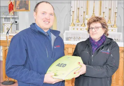  ?? ERIC MCCARTHY/JOURNAL PIONEER ?? Daniel MacDonald, left, property and finance chairman for St. Mark’s Parish in Burton, accepts a donation of an automated external defibrilla­tor for the parish from Avis McDonald.