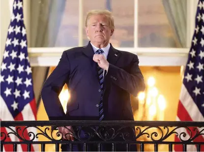  ?? WIN MCNAMEE/GETTY IMAGES ?? President Donald Trump gestures from a White House balcony Oct. 5 after returning from Walter Reed National Military Medical Center, where we was treated for COVID-19.