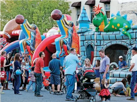  ?? [PHOTO BY ?? Costumed festivalgo­ers wait in line for inflatable rides during Norman’s Downtown Norman Fall Fest in 2014. This year’s event is Friday.