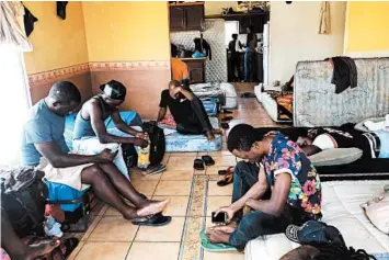  ?? ELLIOT SPAGAT/AP 2019 ?? Cameroonia­ns wait in a rented apartment in Tijuana, Mexico, until their names are called to claim asylum in the U.S.