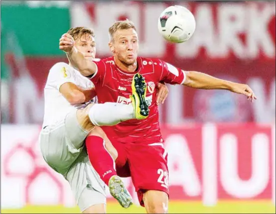  ??  ?? Munich’s Joshua Kimmich (left), and Felix Bruegmann (right), from Cottbus challenge for the ball during the German soccer cup, DFB Pokal, first round match between FC Energie Cottbus and
FC Bayern Munich in Cottbus, Germany on Aug 12. (AP)