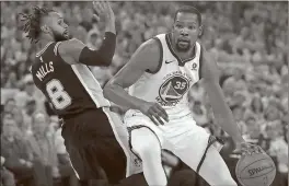  ??  ?? Ben Margot / AP Golden State’s Kevin Durant (right) gets by San Antonio’s Patty Mills in Saturday’s game.