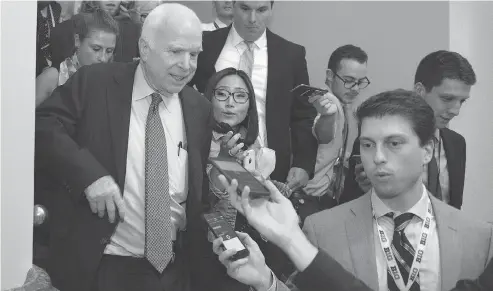  ?? CLIFF OWEN / THE ASSOCIATED PRESS ?? Sen. John McCain, front left, is pursued by reporters after casting a “no” vote on a measure to repeal parts of Obama’s health care law.