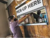  ??  ?? Jaci Laruso picks up an order at Mare Island Brewing Co. Ferry Taproom, which had to close its indoor dining area.