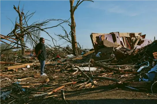  ?? SCOTT OLSON/GETTY IMAGES ?? Cornelius Williams looks at what remains of his home after a tornado hit the area Friday evening in Rolling Fork, Miss.