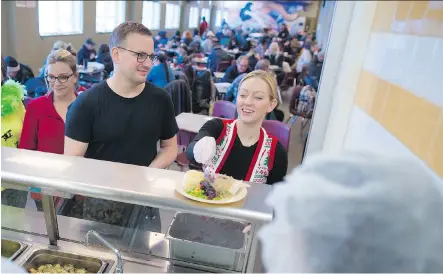  ?? GAVIN YOUNG ?? Volunteer Sarah Tubman adds cranberry sauce as fellow volunteers line up to serve a turkey lunch at the Calgary Drop-In Centre on Christmas Day in Calgary. The meal was sponsored buy Luke’s Drug Mart and Progress Energy. The centre carved up 38 turkeys...