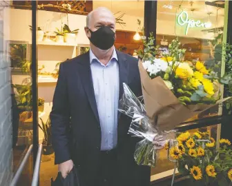  ?? DARRYL DYCK/ THE CANADIAN PRESS ?? NDP Leader John Horgan buys a bouquet of flowers during a campaign stop in Pitt Meadows on Friday. All the leaders were offering big bouquets of promises to the electorate.