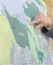  ?? JOHN KENNEY/FILES ?? This map at a press conference in June 2015 shows the zone in western Pierrefond­s, in light green, to be conserved as eco-territory. The Manchester Brighton/Uni-Dev strip of land is below the hand.