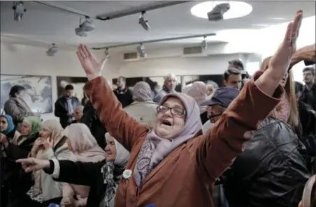  ?? AMEL EMRIC — THE ASSOCIATED PRESS ?? A Bosnian woman raises her arms upon hearing the sentence at the end of former Bosnian Serb military chief Gen. Ratko Mladic’s trial at the memorial center in Potocari, near Srebrenica, Bosnia, Wednesday.