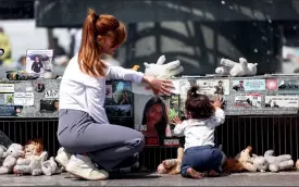  ?? — REUTERS ?? A woman and child are seen near memorabili­a and pictures of the hostages kidnapped in the deadly October ˆ attack on Israel by Hamas from Gaza, at DizengoŽ Square in Tel Aviv, Israel, on Sunday.