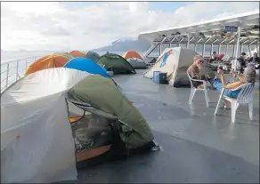  ?? — THE WASHINGTON POST ?? Tents dot the deck of the MV Columbia as it cruises the Alaska coast. Campers use duct tape to mark their places.