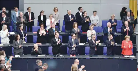  ?? — AFP ?? German Chancellor Angela Merkel (R) and members of the parliament applaud Norbert Lammert (not in picture), president of the Bundestag (lower house of parliament), after he gave a speech to open a session at the Bundestag in Berlin on Tuesday.