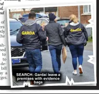  ?? ?? SEARCH: Gardaí leave a premises with evidence bags