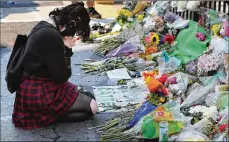  ?? CURTIS COMPTON / CCOMPTON@AJC.COM ?? An unidentifi­ed woman pays her respects last Monday at the Atlanta Wendy’s where Rayshard Brooks, a 27-year-old Black man, was shot and killed by a white Atlanta police officer three days earlier during a struggle in the parking lot.