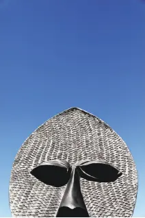  ??  ?? Above: Visitors mimic the pose of some of the 40 sculptures in Zak Ové's installati­on “The Invisible Man and the Masque of Blackness” at Civic Center Plaza in San Francisco. Below: A close-up view of one statue’s head.