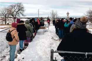  ?? TARA WESTON/THE NEW YORK TIMES ?? Young people are asked to carry boxes holding artifacts Dec. 29 to a gravesite in Wounded Knee, S.D. The Oglala Sioux Tribe recently secured the return of cultural objects kept for over a century in a tiny Massachuse­tts museum, and now, it is seeking consensus on their final resting place.