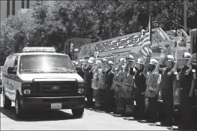  ?? Associated Press photo ?? Firefighte­rs salute as a van carrying the body of Fire Capt. Dave Rosa passes them during a procession Monday in Long Beach, Calif. Rosa was killed Monday morning after a resident of a retirement home opened fire on firefighte­rs responding to a report...