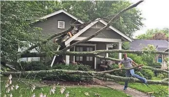  ?? SHELLY MAYS, THE (NASHVILLE) TENNESSEAN ?? Chuck Ingram makes his way out of his home in July after a tree fell on his home in Franklin, Tenn., south of Nashville. Nashville was ranked as the USA’s windiest city in 2016 by CoreLogic.