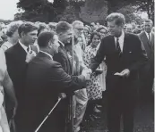  ?? U.S. National Archives and Records Administra­tion ?? President John F. Kennedy greets Peace Corps volunteers on the South Lawn of the White House in 1962. Kennedy created the agency through an executive order the previous year.