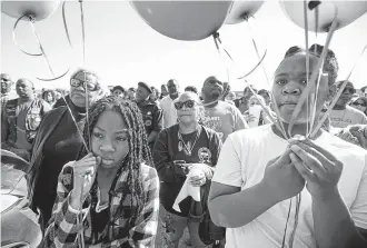 ?? Melissa Phillip / Staff photograph­er ?? Zyriah Taylor, 11, left, and her cousin Jaskya Lee-Mills, 13, brought balloons to a community rally in memory of 7-year-old Jazmine Barnes, who was killed in a shooting that has captivated the nation.