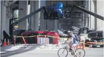  ??  ?? A cyclist rides past a film set for the movie Deadpool 2.