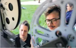  ??  ?? Chicago Film Society projection­ist Rebecca Lyon and executive director Julian Antos set up before an outdoor screening in Logan Square on July 7.