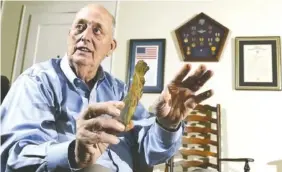  ?? STAFF PHOTO BY TIM BARBER ?? Vietnam veteran and former POW William A. Gauntt holds a piece of titanium from the engine of his airplane at his home on Lookout Mountain.