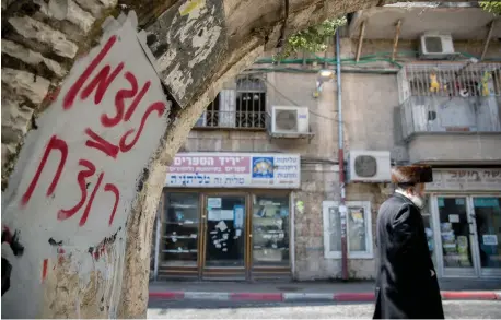  ?? (Yonatan Sindel/Flash90) ?? (Below) ‘LITZMAN IS a murderer’ reads graffiti in Jerusalem’s Mea She’arim neighborho­od, referring to the former health minister.