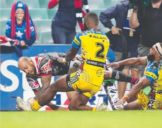  ??  ?? Blake Ferguson dives over for his third try in the Roosters’ win over Parramatta, with the Eels losing Corey Norman to injury during the game. Picture: BRETT COSTELLO