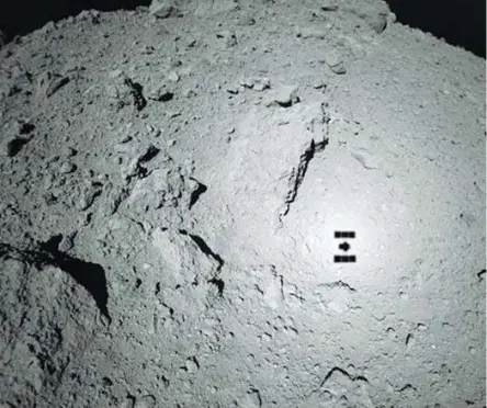  ??  ?? L’immagine
Nella foto grande: la sonda giapponese Hayabusa 2 fotografa l’asteroide Ryugu da 70 metri di altitudine; sull’asteroide è visibile l’ombra proiettata dalla stessa sonda durante il sorvolo (foto Jaxa)