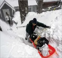  ?? JAE C. HONG/ASSOCIATED PRESS ?? Angie Gourirand walks down the snow-covered steps of her home Tuesday with groceries on a sled in Running Springs, California. Beleaguere­d California­ns got hit again as a new winter storm moved into the already drenched and snow-plastered state.