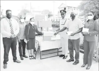  ??  ?? The Giftland Team (left) handing over the masks to the Police Commission­er, Nigel Hoppie (third from right), Minister of Home Affairs Robeson Benn & Permanent Secretary Mae Thomas.