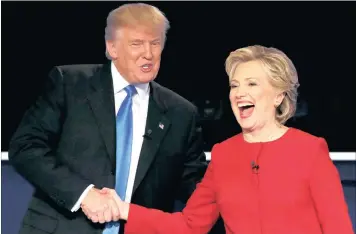  ??  ?? Republican US presidenti­al nominee Donald Trump shakes hands with Democratic nominee Hillary Clinton at the conclusion of their first presidenti­al debate at Hofstra University in Hempstead, New York. Mutual insults were traded during the debate.