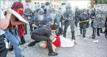  ??  ?? File photo shows a woman who was pushed down by police is helped by a protester while police try to disperse a crowd, after a not guilty verdict in the murder trial of Stockley in St. Louis, Missouri, US. — Reuters photo