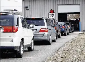  ?? TY GREENLEES / STAFF ?? Cars line up for free bottled water Friday. The boil advisory stemming from Wednesday’s water main break in Dayton has since been lifted.