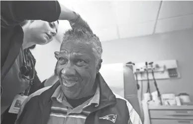  ?? DAVID WALLACE/THE REPUBLIC ?? Harmoni Peebles removes a suture from the head of Vincent Hall at Circle the City in Phoenix.