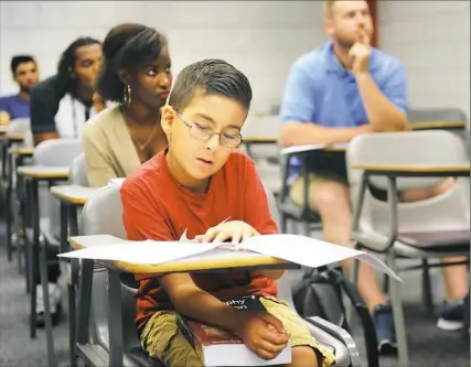  ?? Nate Guidry/Post-Gazette ?? William Maillis reads the course syllabus during a Religions of the World class at the Community College of Allegheny County Boyce Campus.