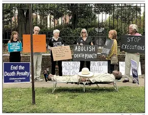  ?? Sherry Simon via AP ?? Pulaski County Circuit Judge Wendell Griffen lies on a cot in the role of a condemned prisoner awaiting execution during a protest outside the Governor’s Mansion in April 2017. Almost simultaneo­usly, he issued an order blocking the use of a component of the state’s lethal-injection drugs.