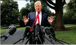  ?? ASSOCIATED PRESS ?? PRESIDENT DONALD TRUMP’S hair is ruffled by a breeze as he speaks to the media on the South Lawn of the White House in Washington Wednesday en route to a day trip to New York.