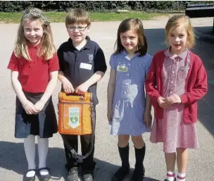  ??  ?? ●● Daisy, Joe, Decca and Matilda with the new defibrilla­tor. Daisy and Matilda are from Pott Shrigley School and Joe and Decca are from Bollington Cross Primary