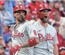  ?? JEFF ROBERSON/AP ?? The Phillies' Nick Castellano­s (8) and Bryce Harper (3) celebrate after scoring on a single by Jean Segura during the ninth inning against the Cardinals on Friday.