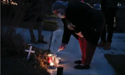  ?? Photograph: Joshua A Bickel/AP ?? A neighbor lights a candle at a small memorial near the site of the fatal police shooting of Andre Hill by police in Columbus, Ohio.