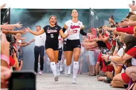  ?? Stadium. Photograph: Dylan Widger/USA Today Sports ?? ▲ Nebraska Cornhusker­s outside hitter Merritt Beason (13) and libero Lexi Rodriguez (8) run out of the tunnel before Wednesday’s match against the Omaha Mavericks at Memorial