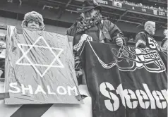  ?? JEFFREY BECKER/USA TODAY SPORTS ?? Fans hold signs at Heinz Field to honor the victims of the shooting at the Tree of Life Synagogue.