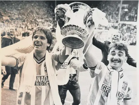  ?? ?? Former Posh star Micky Gynn (right) lifts the FA Cup at Wembley in 1987
