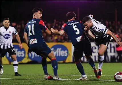  ??  ?? Sligo Rovers’ Kyle Callan-McFadden trips Patrick McEleney to concede a penalty at Oriel Park on Friday night. Pic: David Fitzgerald/Sportsfile