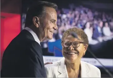  ?? Photograph­s by Myung J. Chun Los Angeles Times ?? CANDIDATES Rick Caruso and Rep. Karen Bass share a smile after their debate Wednesday at the Skirball Cultural Center. Their rancorous exchanges built on the coarser tone the campaign has taken in recent weeks.