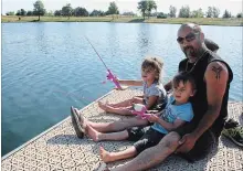  ??  ?? Four-year-old twins Michelle and Nicole Gaudet with their dad Kevin at Sunday's fishing derby in Welland.