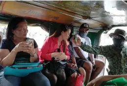  ?? AVITO C. DALAN/PNA ?? A member of the Joint Task Force-national Capital Region checks temperatur­e of people in a passenger jeepney using thermal scanner as the 30-day ‘community quarantine’ in Metro Manila begins on March 15, 2020.